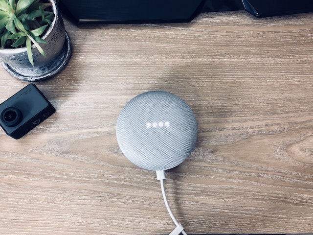 Google smart speaker sitting on a work desk.