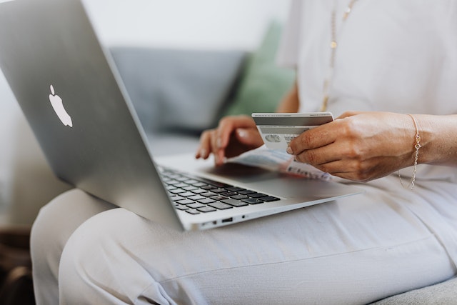 Woman purchases something with a credit card on her laptop