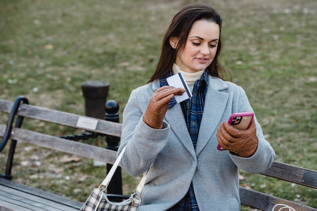 Woman in a coat using Stripe payment processing on her cell phone