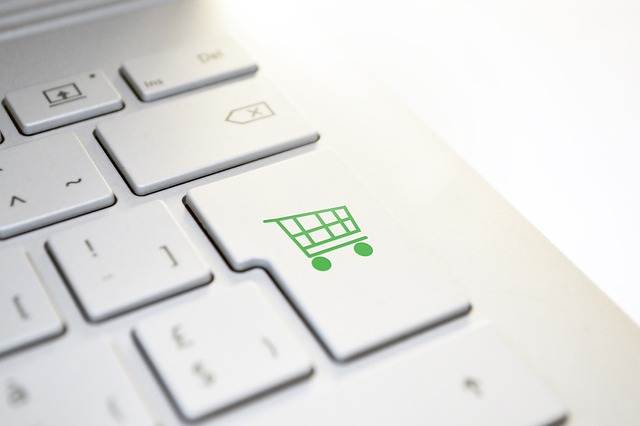 A laptop keyboard showing a button with a green shopping cart on it