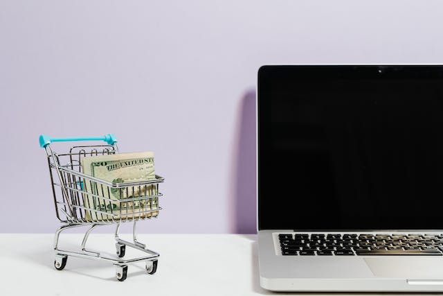 Shopping cart sitting beside a laptop computer to show an increased conversion rate