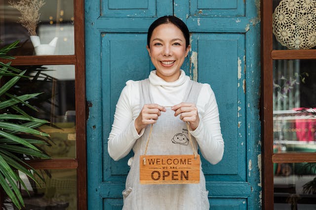 Small business owner standing in front of her shop