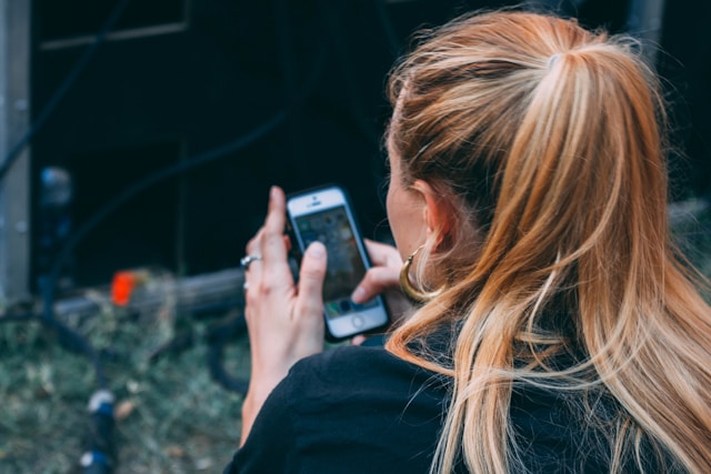 A young woman checks her iPhone.