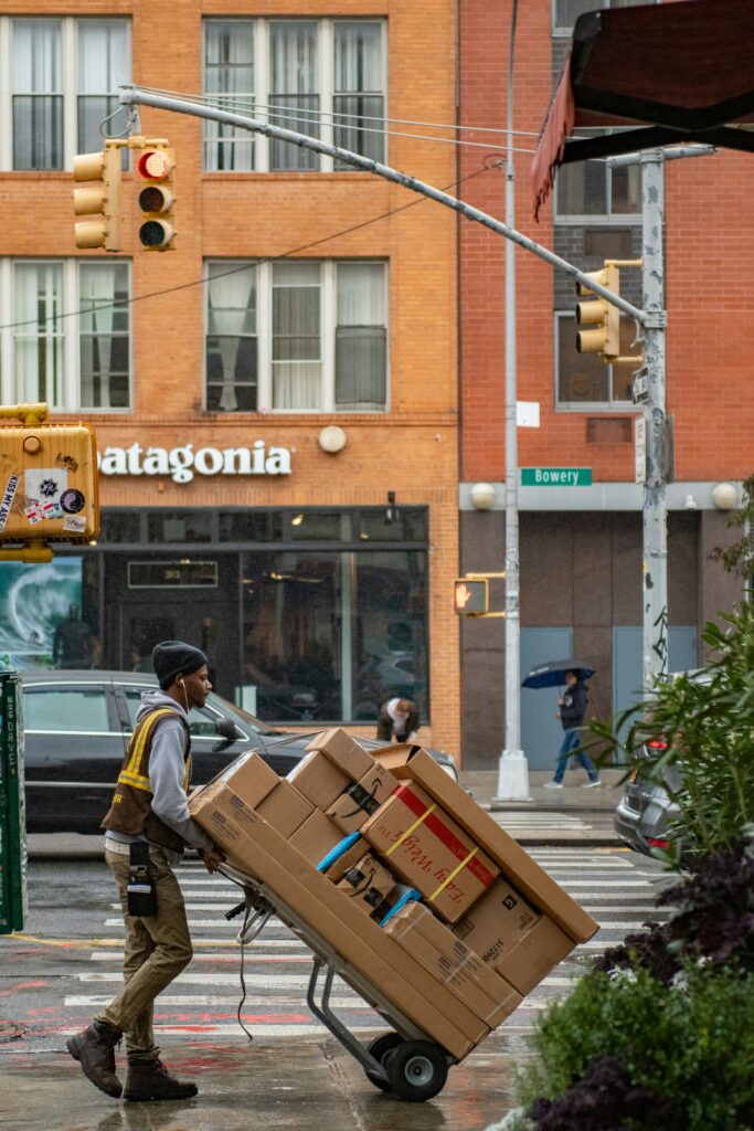 A delivery man pushing a dolly full of packages