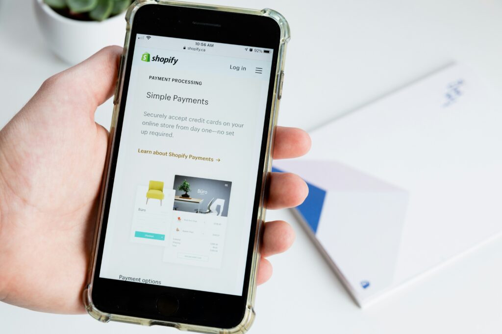 A person holding a phone with Shopify